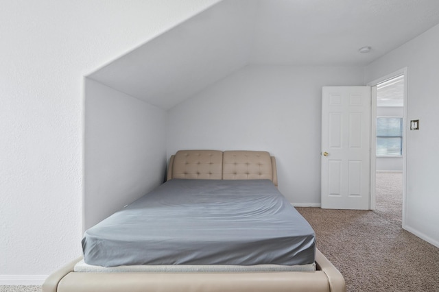 bedroom with lofted ceiling, carpet, and baseboards