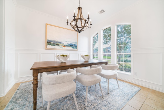 dining room featuring ornamental molding, light tile patterned flooring, visible vents, and a decorative wall