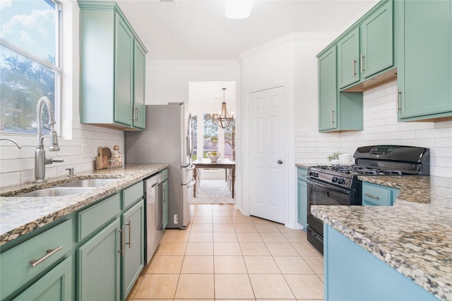 kitchen featuring crown molding, black gas range, stainless steel dishwasher, a sink, and green cabinetry