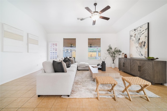 living room featuring ceiling fan, baseboards, vaulted ceiling, and light tile patterned flooring