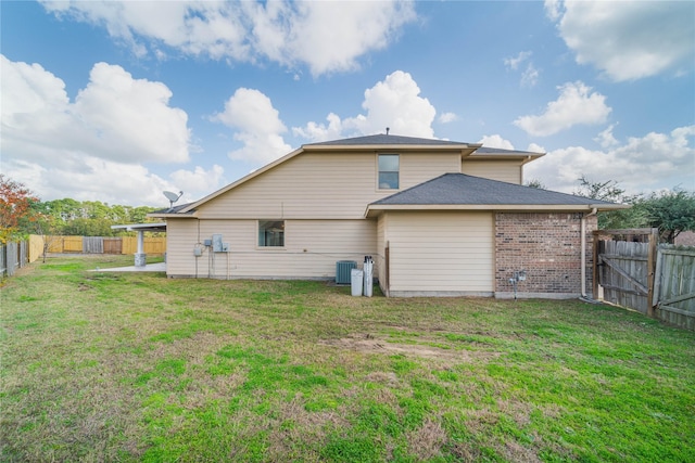 back of property featuring a fenced backyard, central AC unit, a lawn, and brick siding