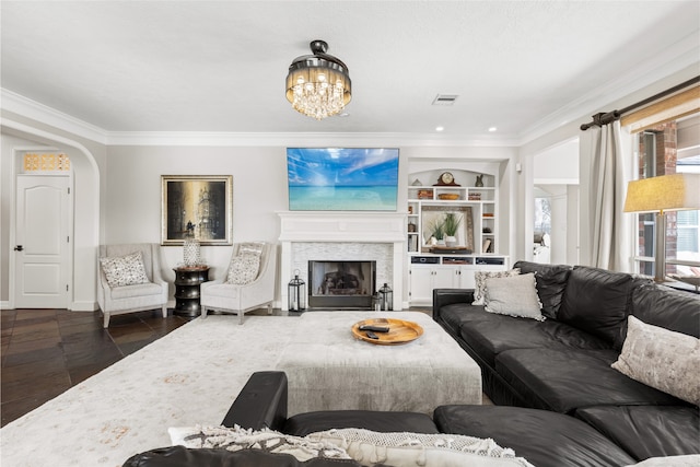 living room with built in shelves, arched walkways, crown molding, a fireplace, and visible vents