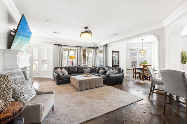 living area featuring baseboards, arched walkways, an inviting chandelier, crown molding, and stone tile flooring