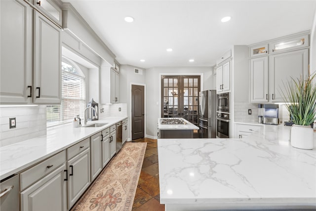 kitchen with a center island, french doors, visible vents, appliances with stainless steel finishes, and a sink