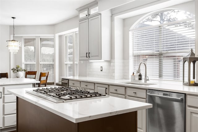 kitchen featuring a wealth of natural light, stainless steel appliances, a sink, and a center island