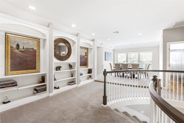 interior space with carpet floors, an upstairs landing, visible vents, and recessed lighting