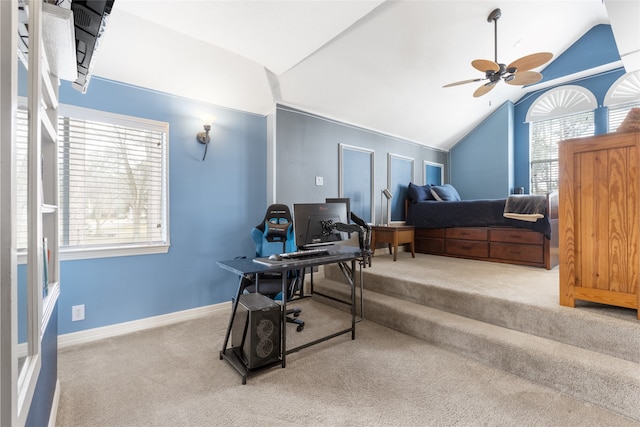 carpeted office space featuring lofted ceiling, ceiling fan, and baseboards