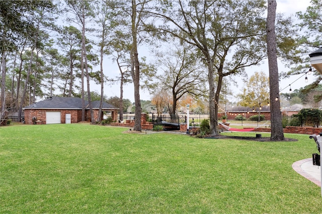 view of yard with an attached garage and fence