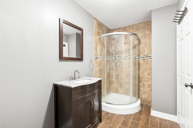 full bath with a shower stall, vanity, and wood tiled floor