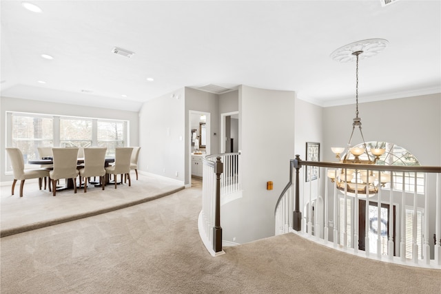 hall featuring a notable chandelier, light carpet, an upstairs landing, baseboards, and visible vents