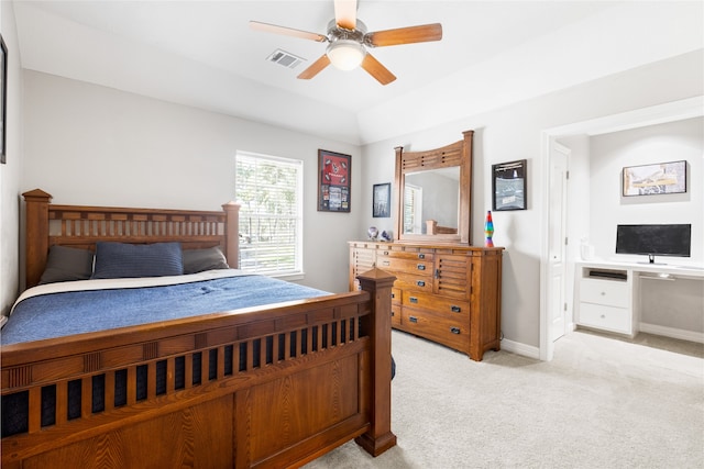 bedroom featuring light carpet, visible vents, baseboards, vaulted ceiling, and built in study area