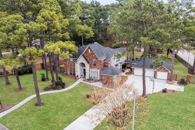 view of front of home featuring an attached garage, fence, driveway, stone siding, and a front lawn