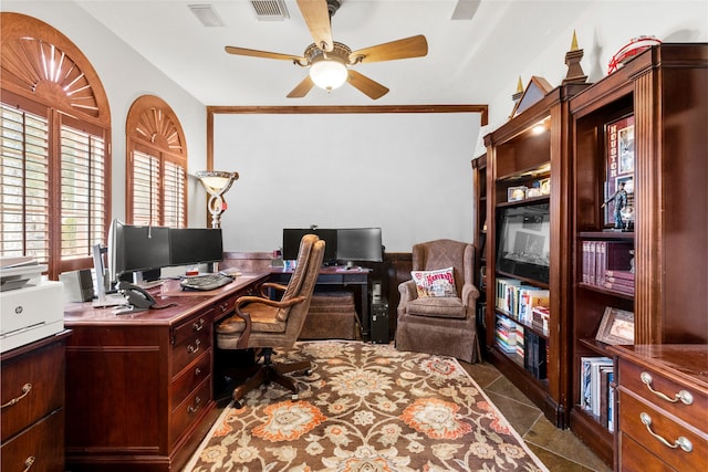 office space featuring ceiling fan, dark tile patterned flooring, and visible vents