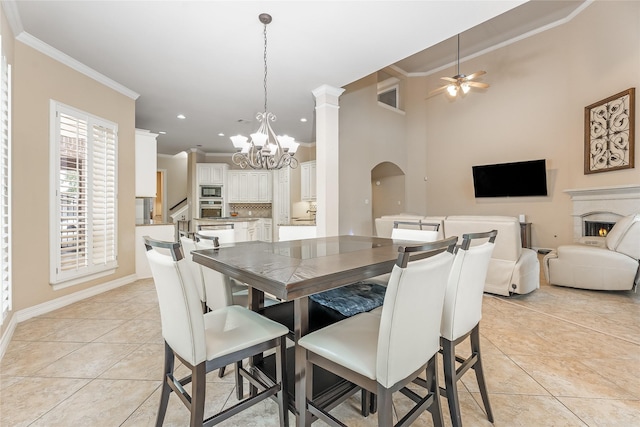 dining space with ornamental molding, arched walkways, light tile patterned flooring, and ceiling fan with notable chandelier