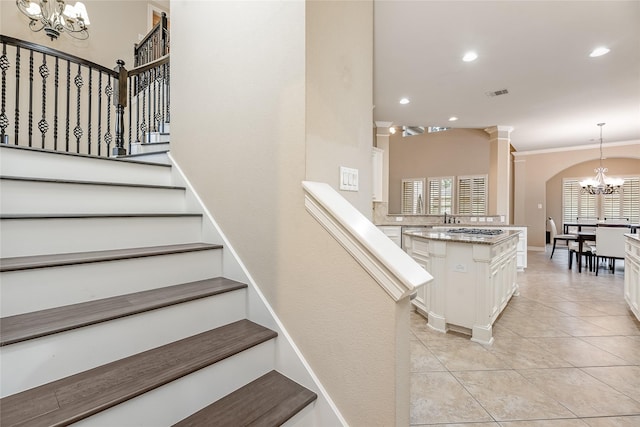 staircase with visible vents, tile patterned flooring, crown molding, a notable chandelier, and recessed lighting