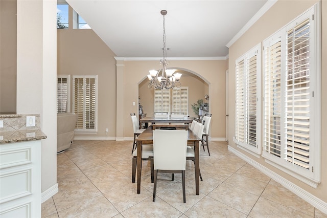 dining room featuring a chandelier, light tile patterned flooring, crown molding, and baseboards