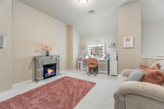 office space featuring vaulted ceiling, carpet floors, a glass covered fireplace, and baseboards