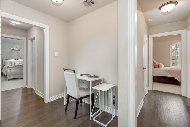 interior space with baseboards, visible vents, and dark wood-style flooring