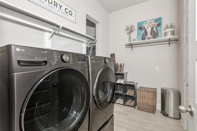 washroom with laundry area, washer and clothes dryer, and light wood finished floors