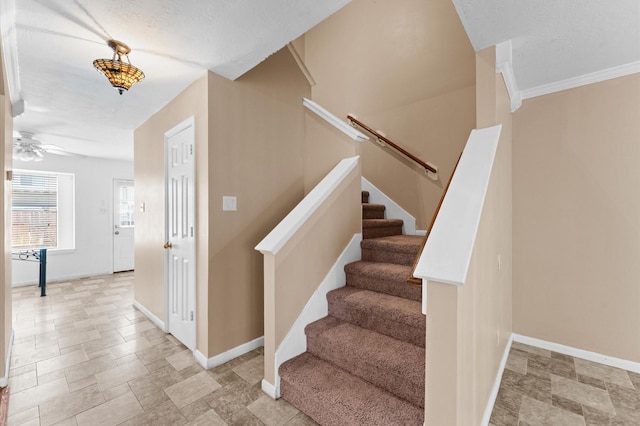 stairway featuring stone finish floor, ceiling fan, a textured ceiling, and baseboards