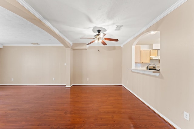 spare room with arched walkways, visible vents, ceiling fan, dark wood-style flooring, and crown molding