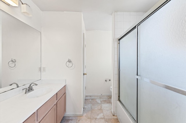 full bath with toilet, vanity, and baseboards