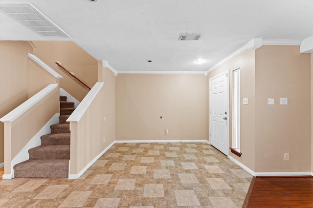 entryway featuring baseboards, visible vents, and ornamental molding