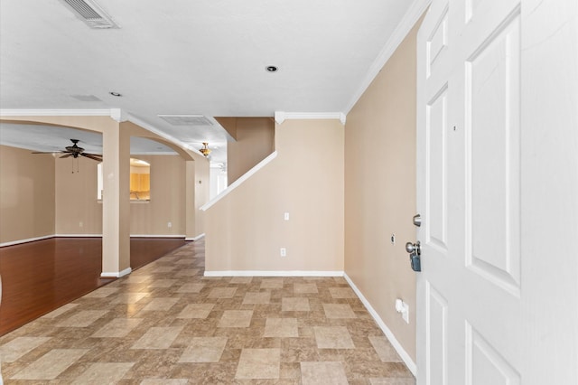 foyer featuring arched walkways, baseboards, visible vents, and crown molding