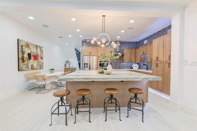 7517 Olympia Dr, Houston, TX 77063 - kitchen featuring pendant lighting, light countertops, a kitchen island, stainless steel fridge, and a kitchen breakfast bar