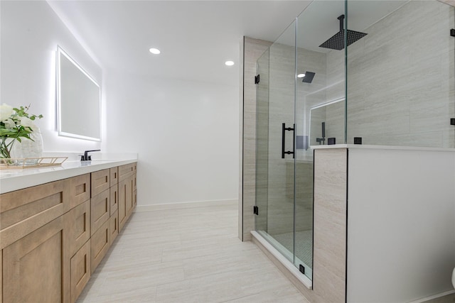 full bathroom with recessed lighting, baseboards, vanity, and a shower stall