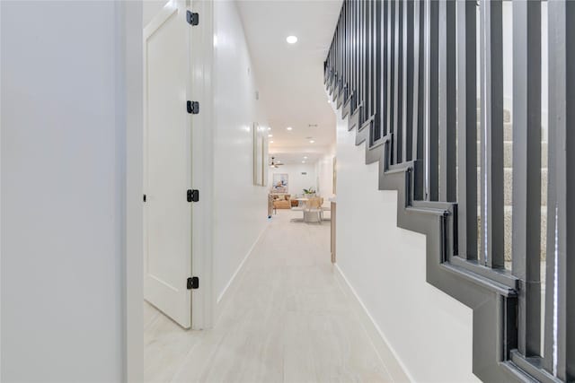 hall with recessed lighting, stairway, and baseboards