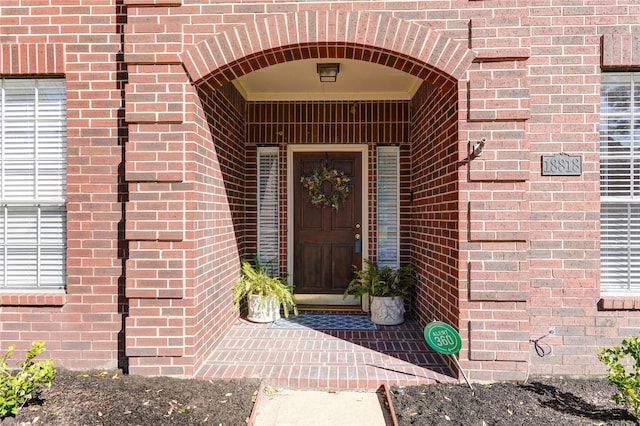 view of exterior entry with brick siding