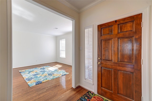 entryway with baseboards, wood finished floors, and ornamental molding