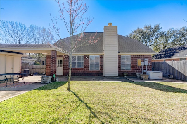 back of property featuring brick siding, a chimney, a patio, and fence