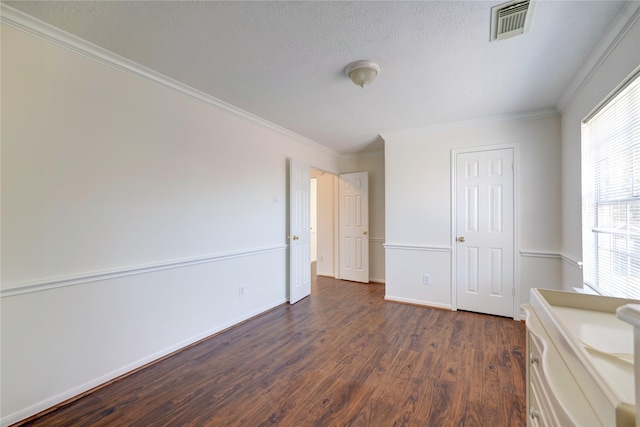 unfurnished bedroom with baseboards, visible vents, dark wood finished floors, a textured ceiling, and crown molding