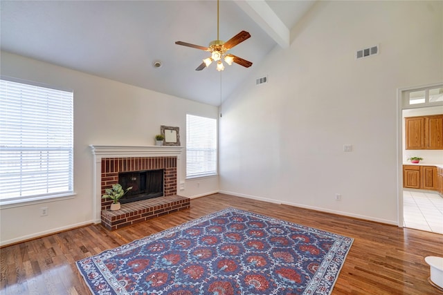 living room with visible vents, a brick fireplace, and a healthy amount of sunlight