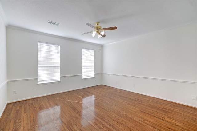 unfurnished room featuring visible vents, ornamental molding, a ceiling fan, and wood finished floors