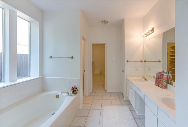 full bathroom featuring a sink, a bath, double vanity, and tile patterned flooring