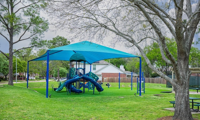 community jungle gym featuring a lawn and fence