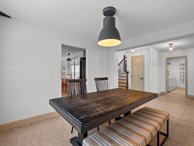 dining space featuring stairs, baseboards, and light tile patterned flooring