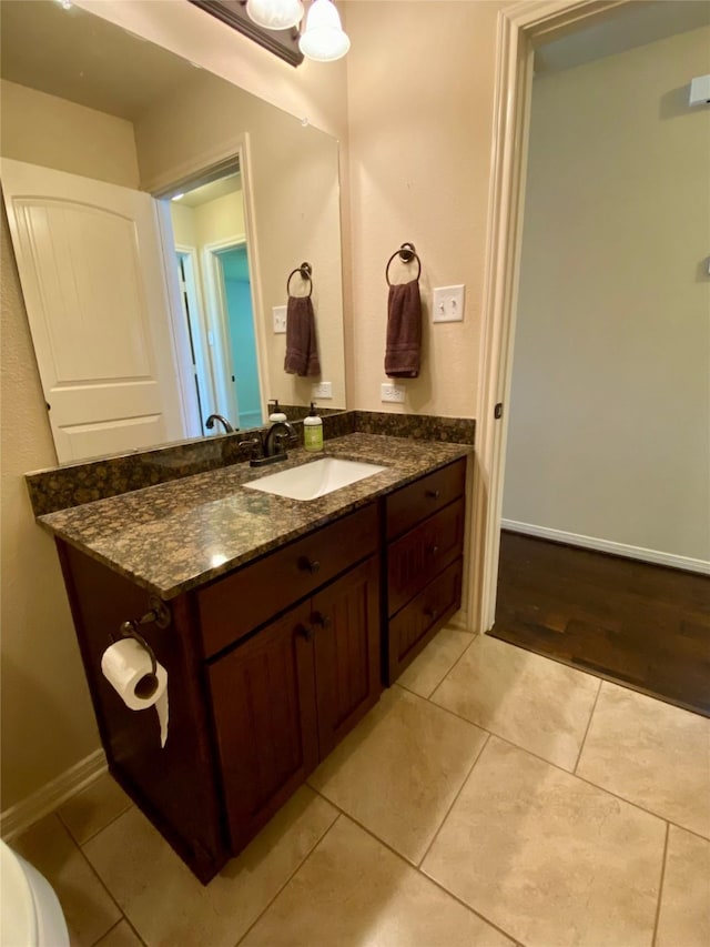 bathroom featuring tile patterned flooring, vanity, and baseboards