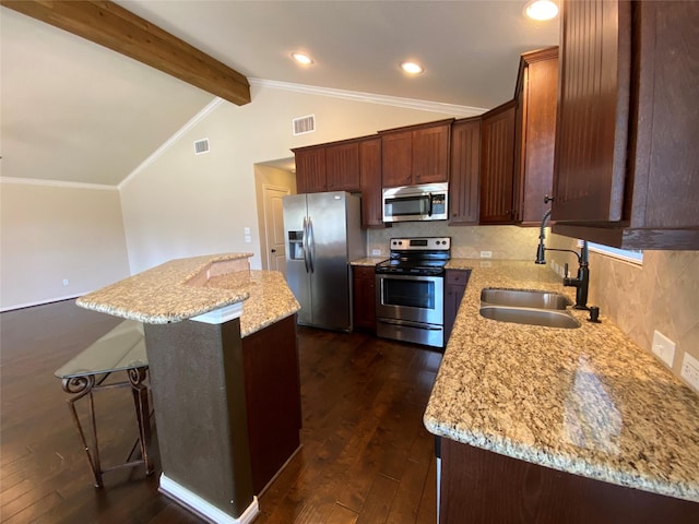 kitchen featuring vaulted ceiling with beams, light stone counters, stainless steel appliances, a sink, and a center island