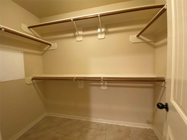 walk in closet with light tile patterned floors