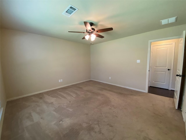 carpeted spare room featuring baseboards, visible vents, and a ceiling fan