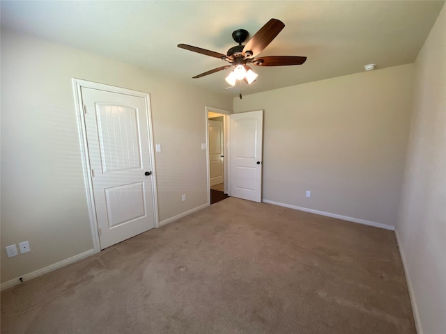 unfurnished bedroom with ceiling fan, carpet flooring, and baseboards