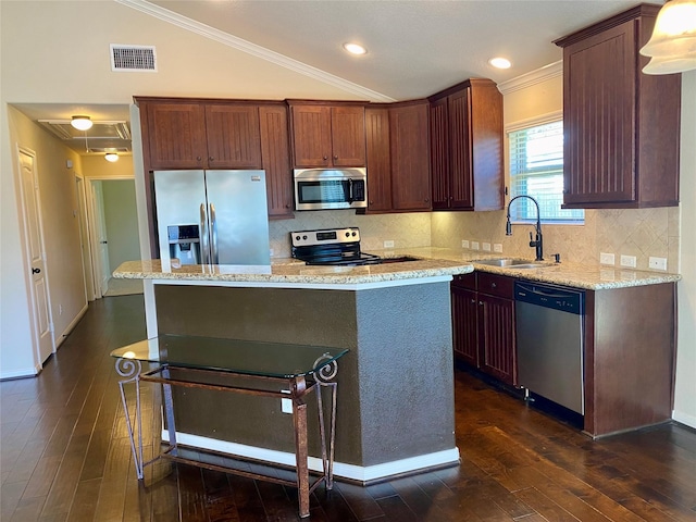 kitchen with visible vents, dark wood finished floors, a center island, stainless steel appliances, and a sink