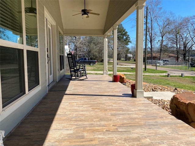 wooden terrace featuring covered porch and ceiling fan