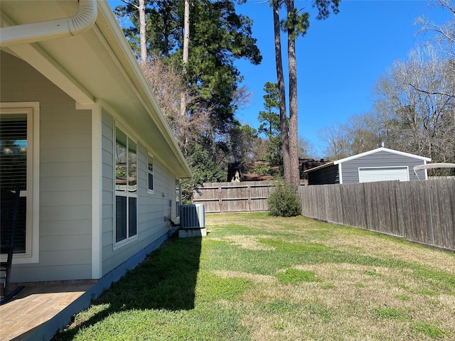 view of yard with central AC and fence