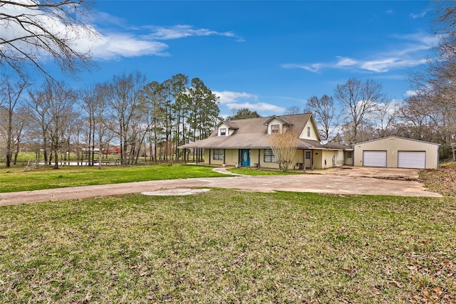 view of front of property featuring a garage, a front lawn, and an outdoor structure