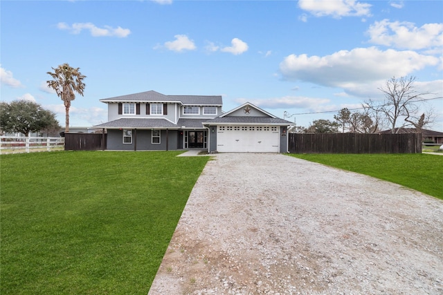 view of front facade featuring a front yard, fence, driveway, and an attached garage